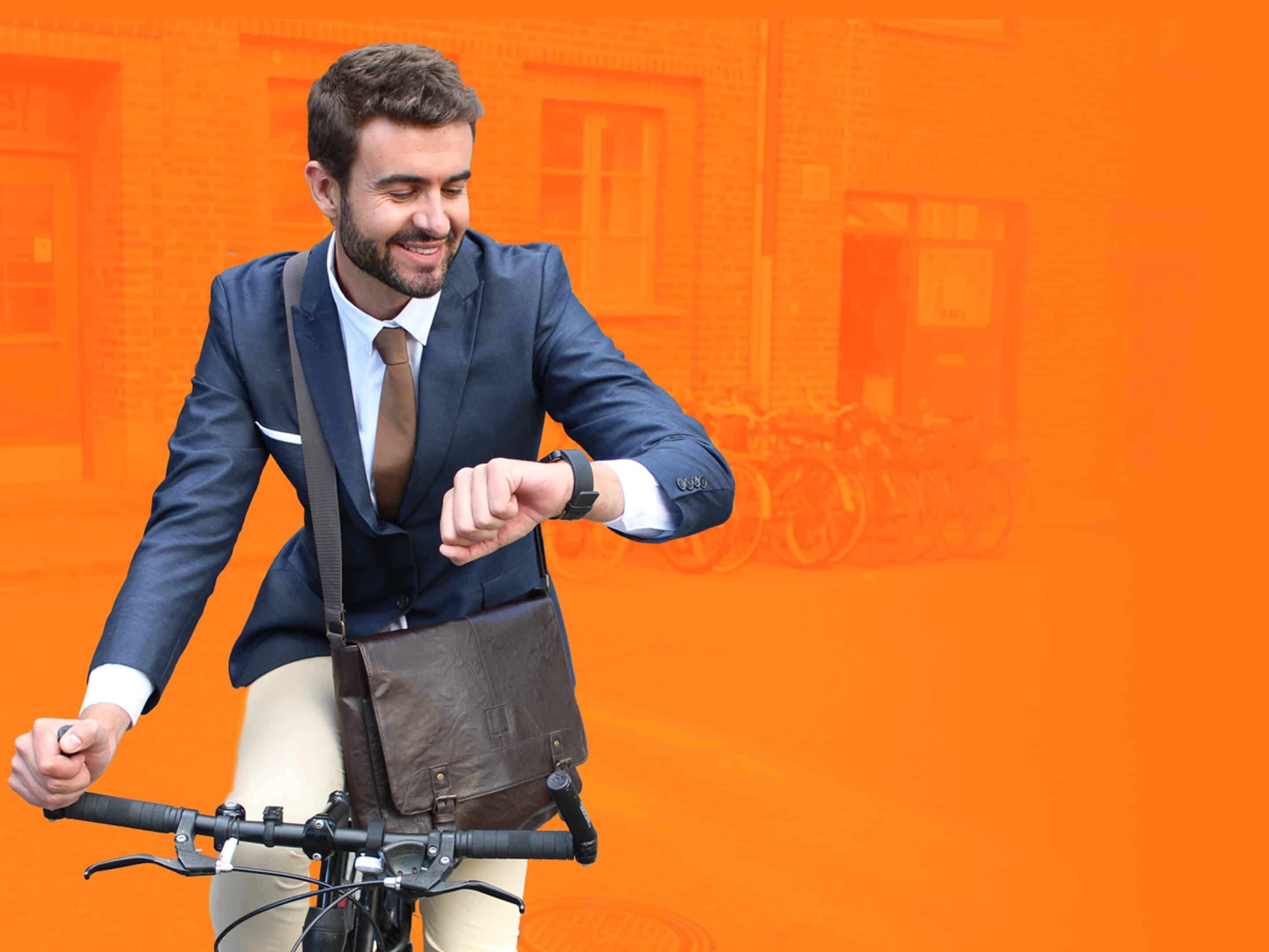 man on bike checking watch on an orange background